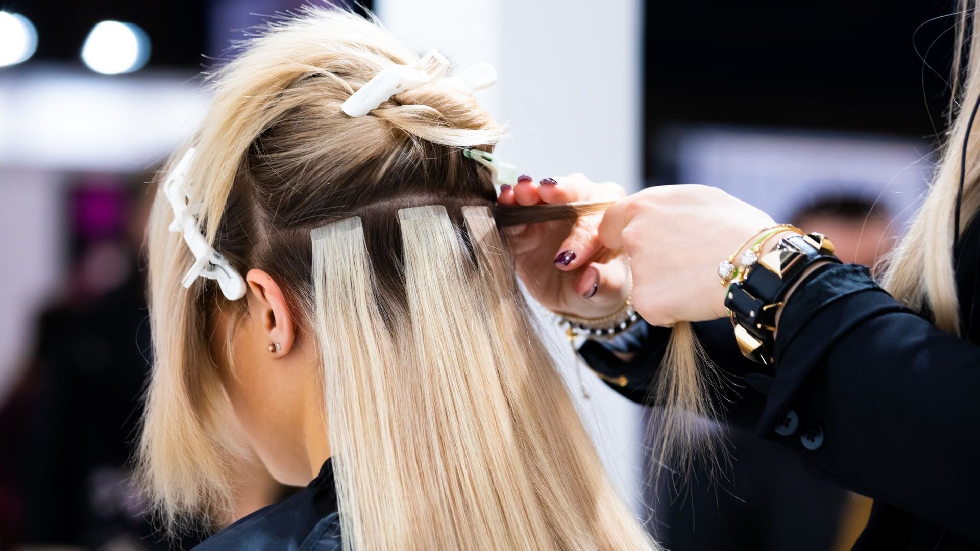 A Woman is Getting Her Hair Done by a Hairdresser — Xquisite Styles in Mount Warrigal, NSW