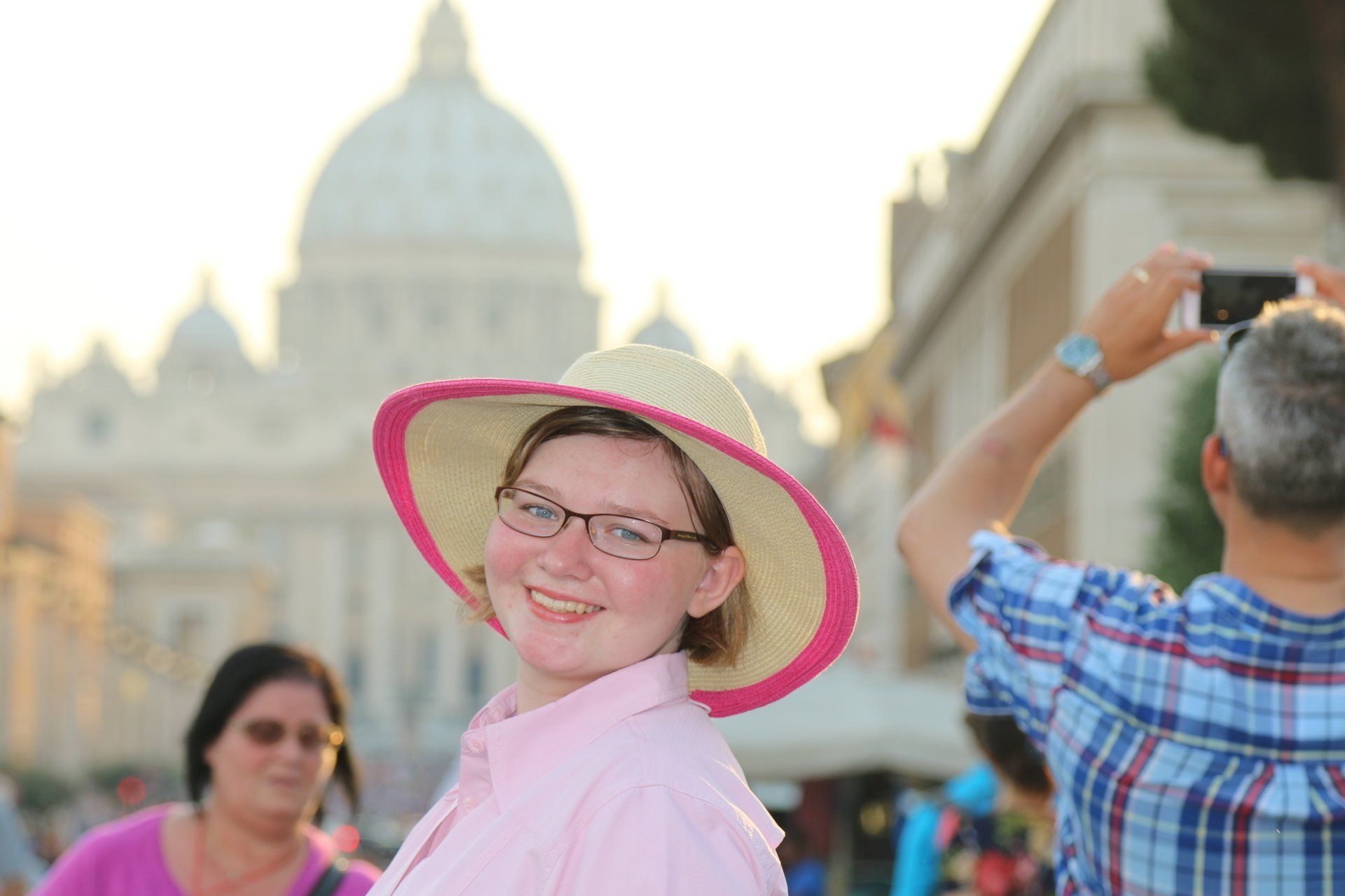 A man is taking a picture of a woman wearing a hat.