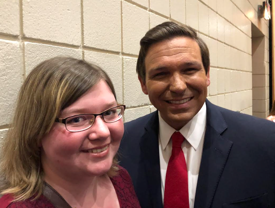 A man in a suit and tie is posing for a picture with a woman wearing glasses.