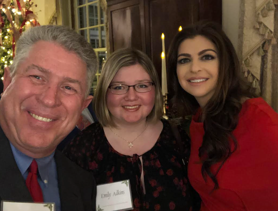 A man and two women are posing for a picture together.