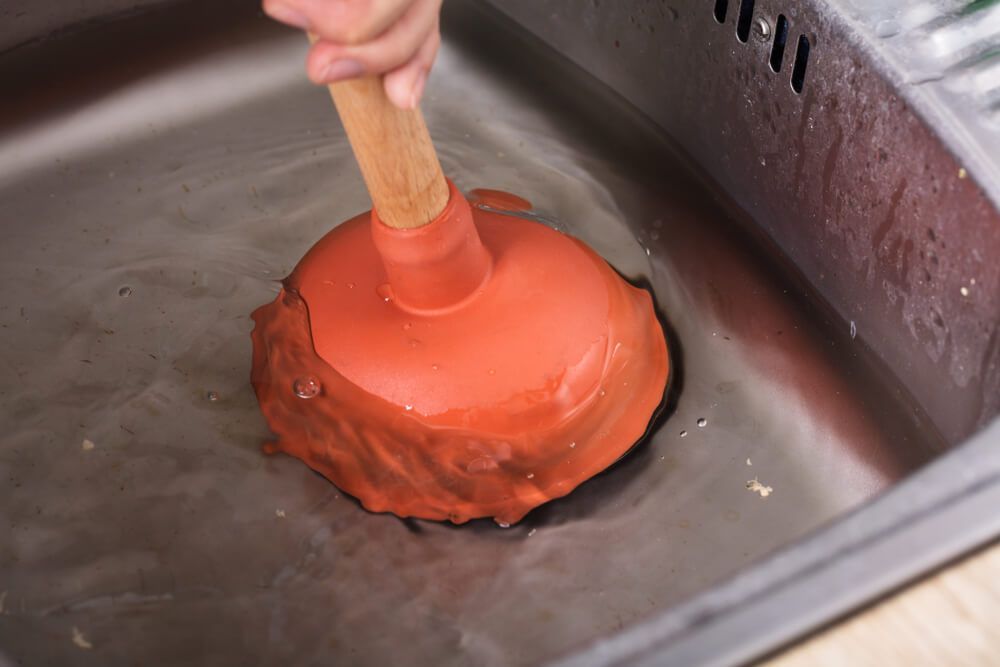 Someone Using a Plunger to Unblock a Sink — Professional Plumber in Toowoomba