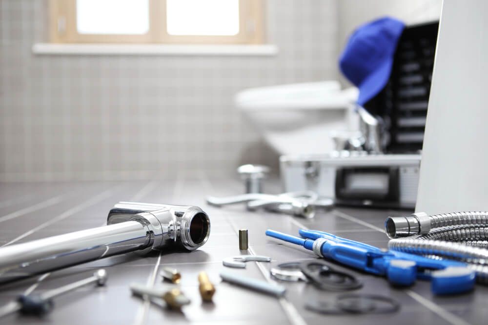 Plumbing Tools Laying on The Bathroom Floor — Professional Plumber in Toowoomba