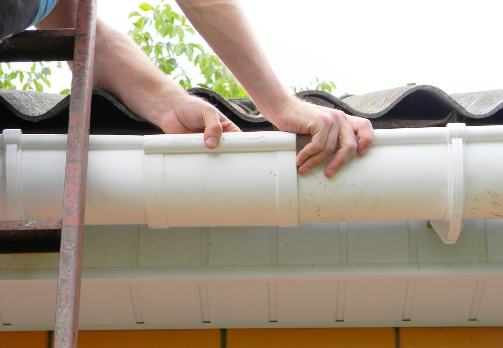 A Person Installing Plastic Gutter on A Roof — Professional Plumber in Toowoomba