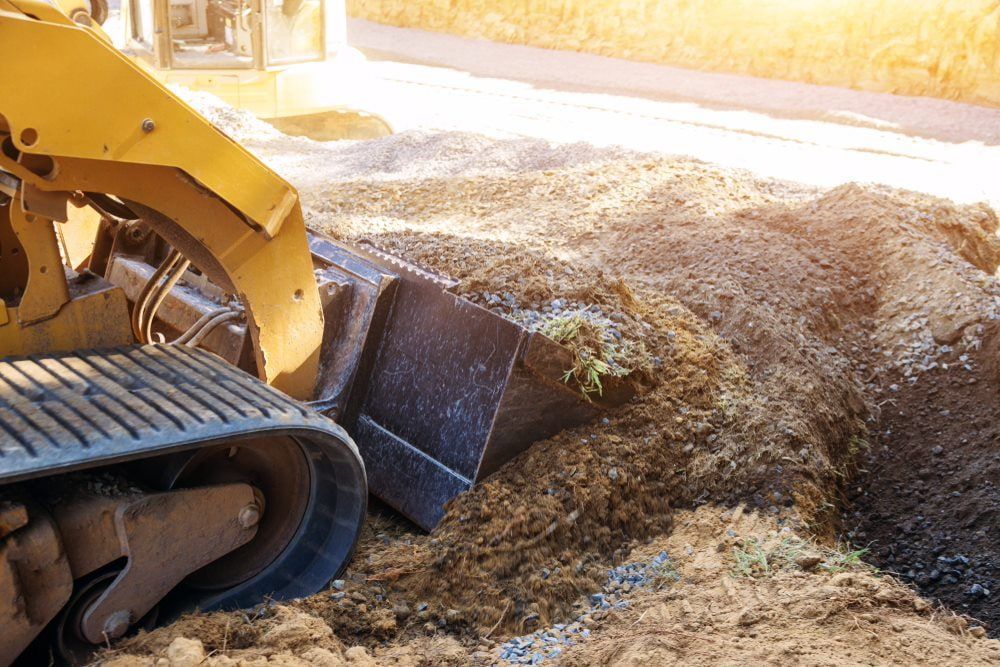 Bulldozer collecting debris in its bucket during the excavation process — Stan Davies Excavations in Glendale, NSW
