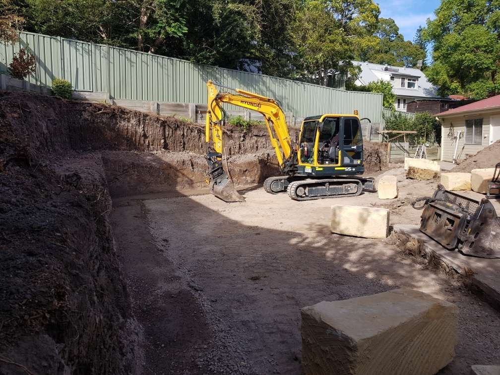 Excavator In A Backyard— Stan Davies Excavations in Glendale, NSW