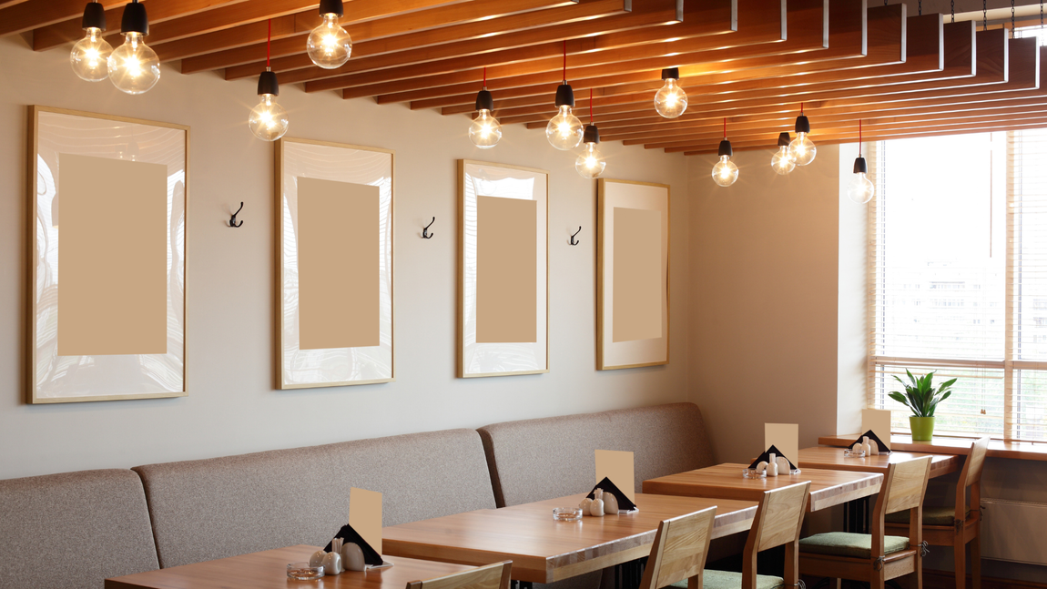 A restaurant with tables and chairs and a ceiling with lights