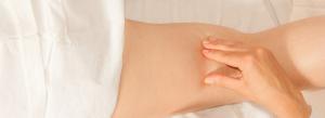a close up of a person 's stomach with a white curtain in the background .