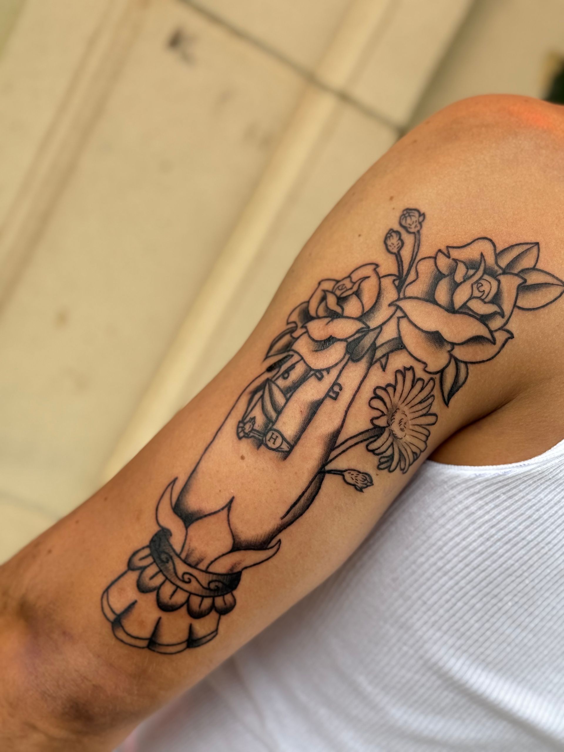 Arm with black floral tattoo design on upper forearm and wrist