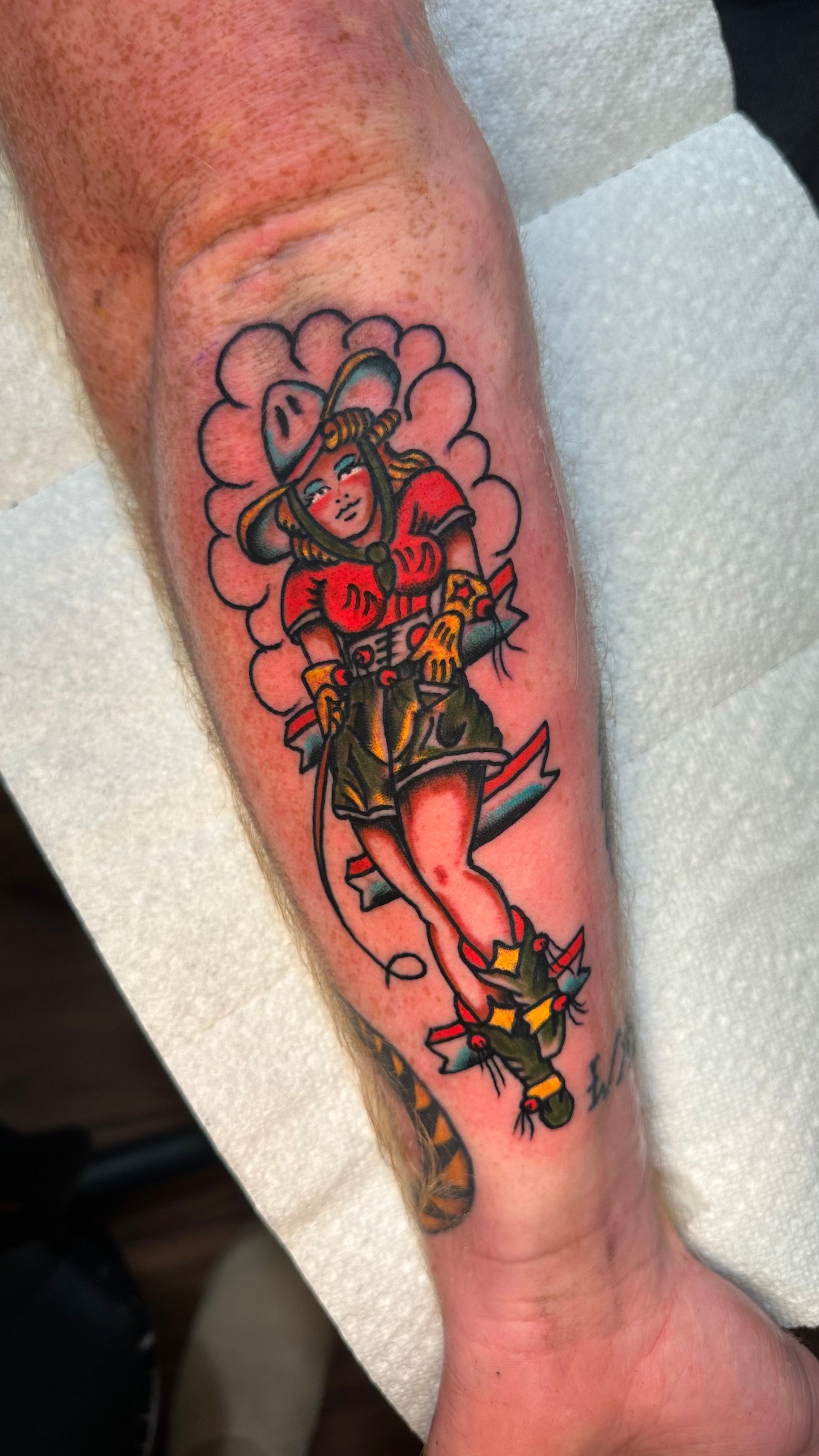 Colorful tattoo of a cartoon-style woman with flowers on a forearm