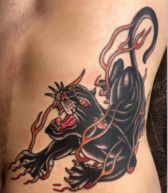Black tiger tattoo with red accents, snarling and rearing up on skin.