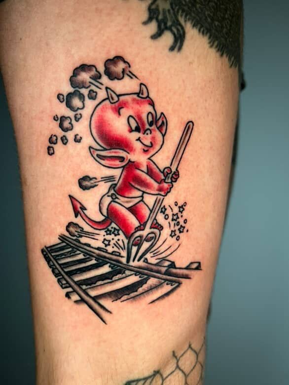 Red cartoon animal in a scarf riding a spark-like scooter over railroad tracks, with smoke puffs above.