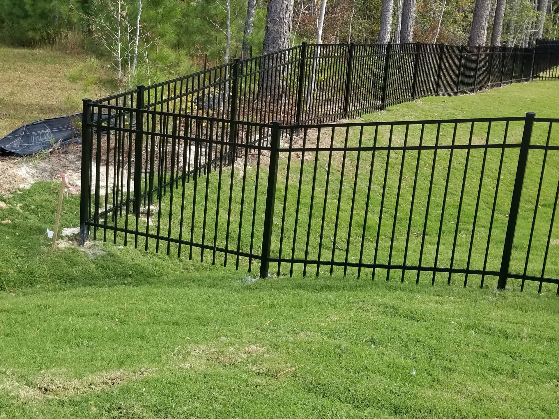 a black aluminum fence with yellow spikes