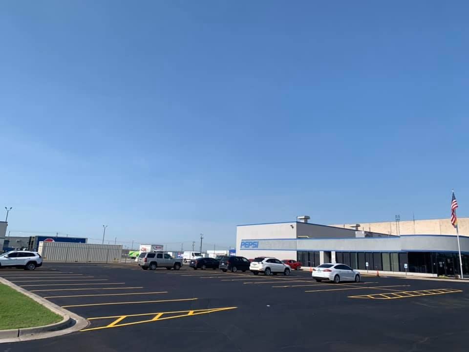 A parking lot with cars parked in front of a building on a sunny day.
