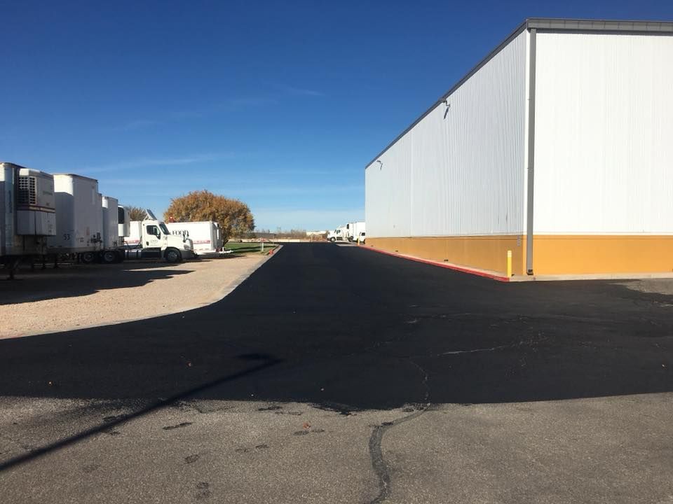 A warehouse with a lot of trucks parked in front of it