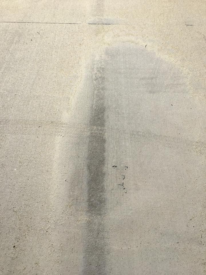 A close up of a concrete floor with a shadow of a person on it.