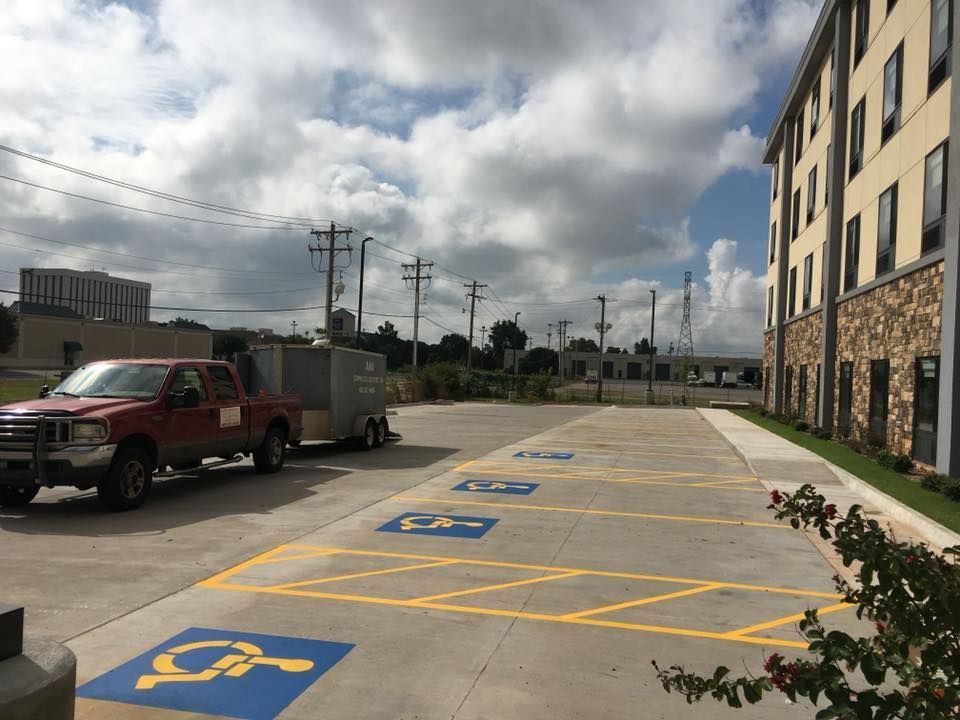 A red truck is parked in a handicapped parking spot.