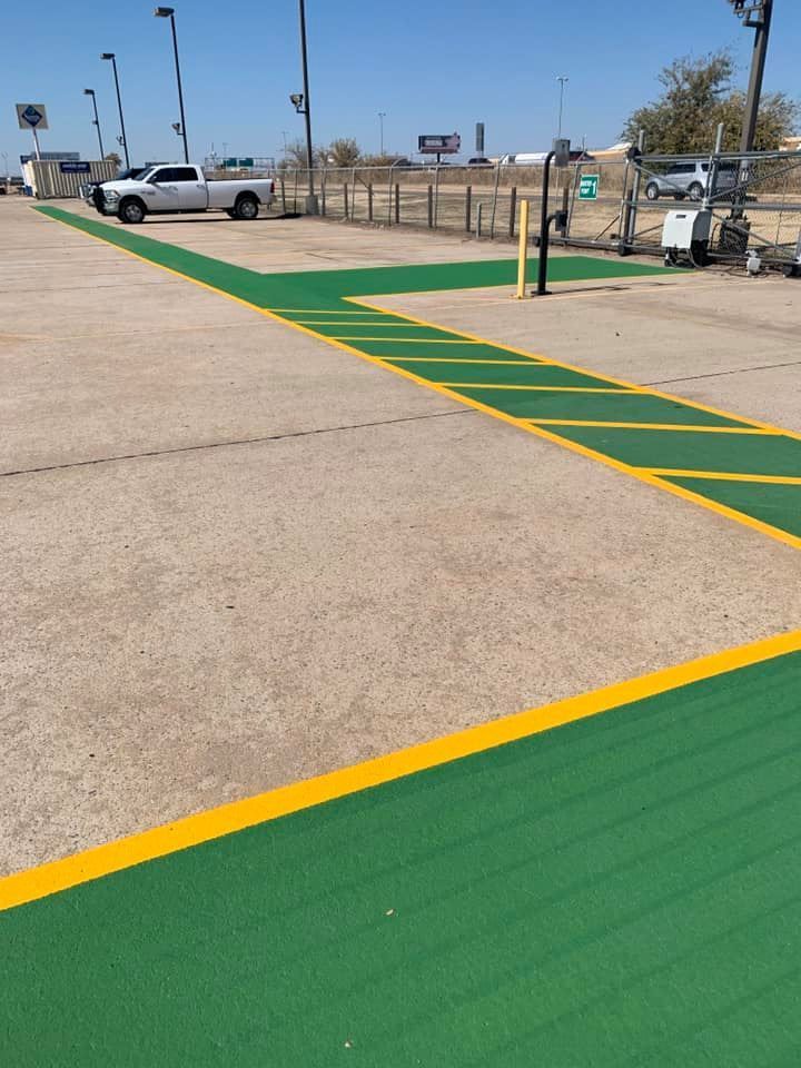A parking lot with a green walkway and yellow lines
