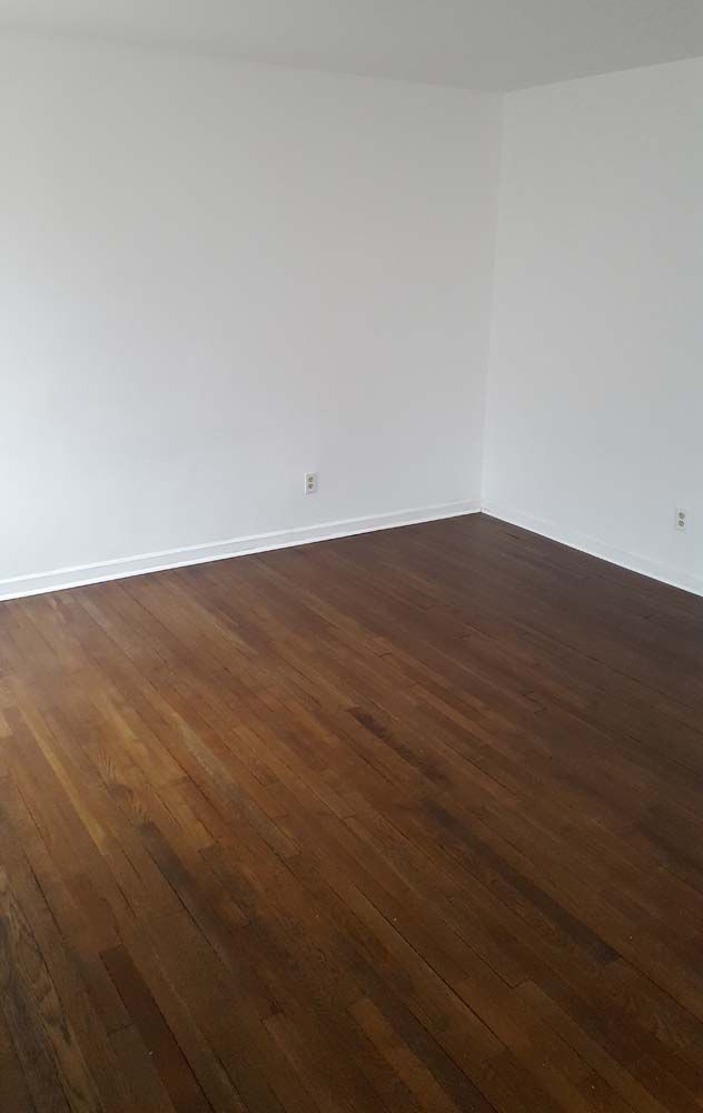 Empty room with hardwood floors and white walls.