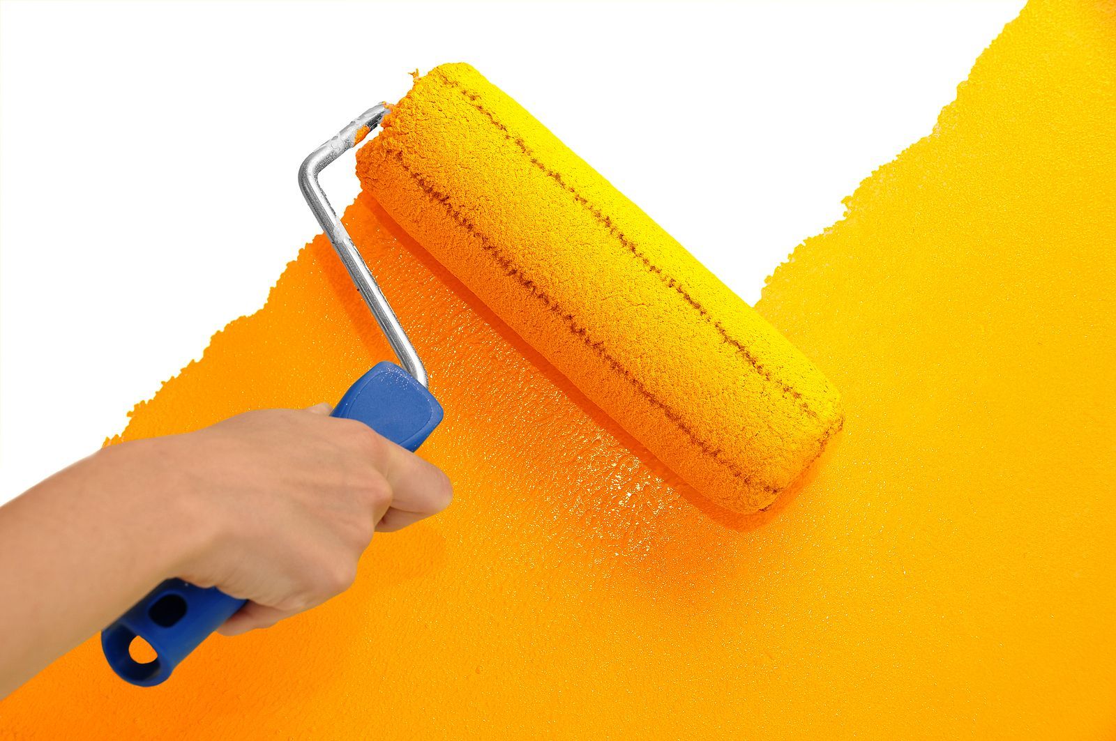Hand using a yellow paint roller to paint a white wall bright orange.