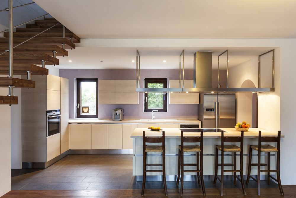 A kitchen with a staircase leading up to the second floor