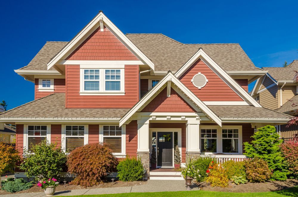 A large house with red siding and a brown roof