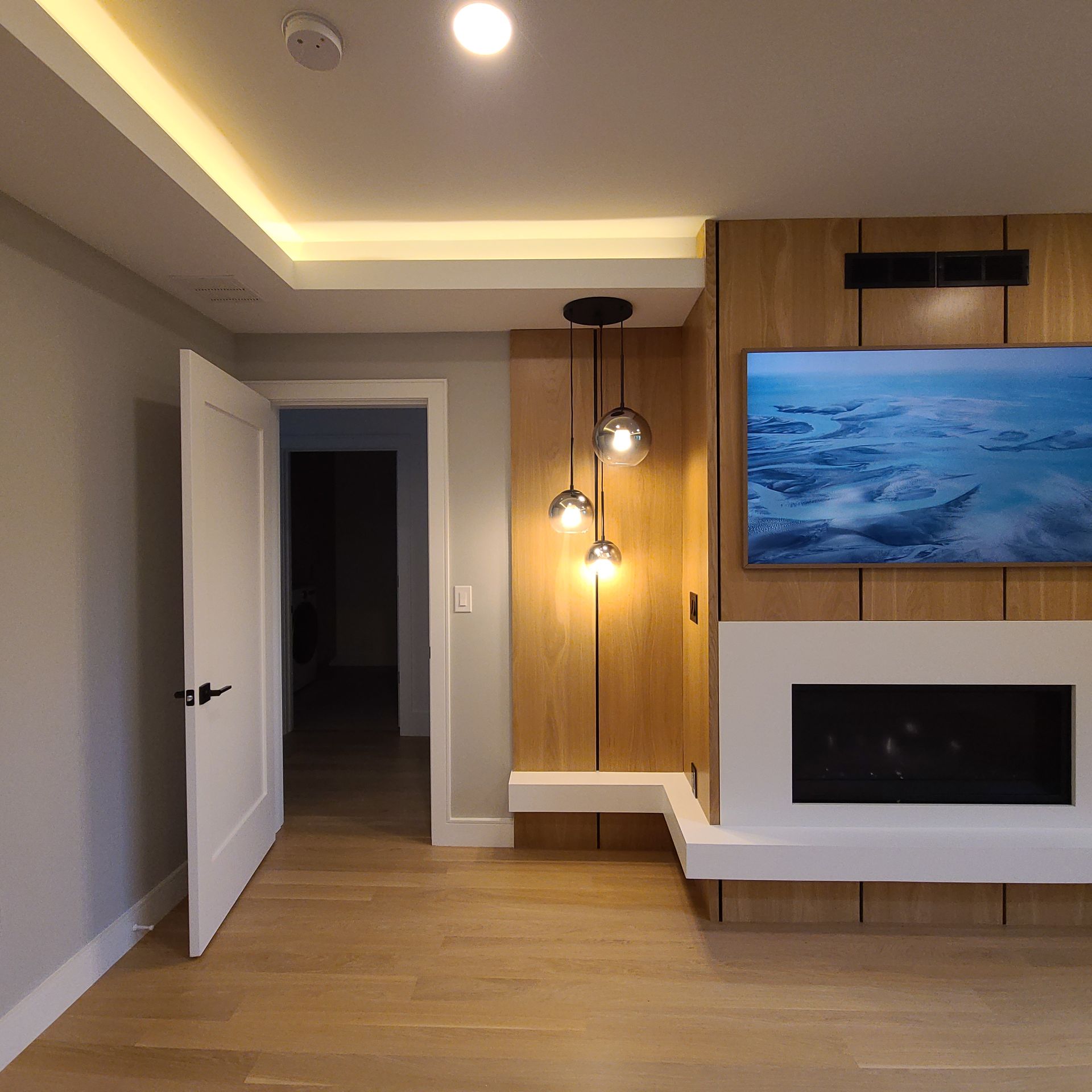 Kitchen ceiling with pendant lights, recessed speakers, and white cabinets.