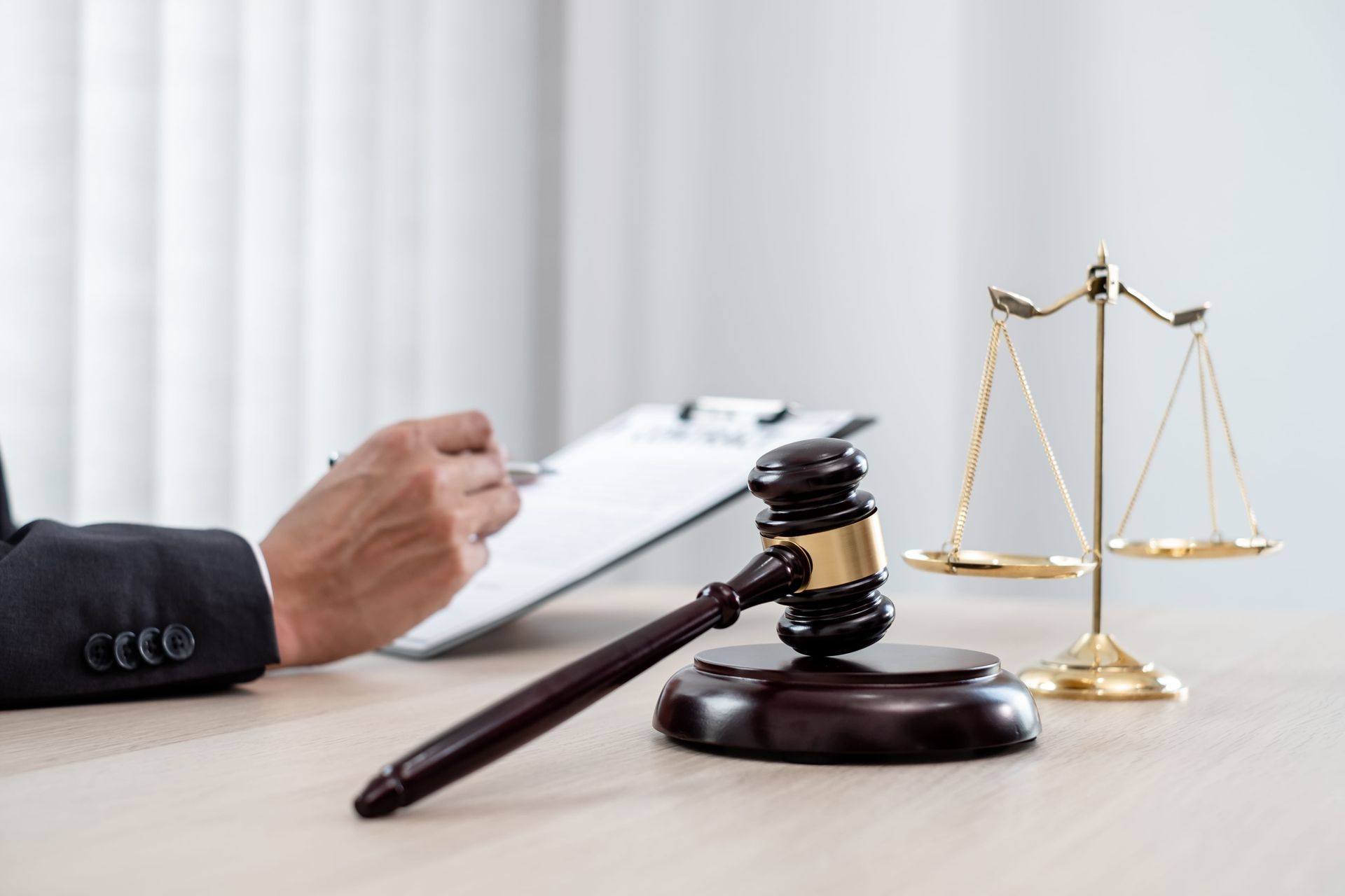 Lawyer’s desk with gavel, scales of justice, and hand writing on documents