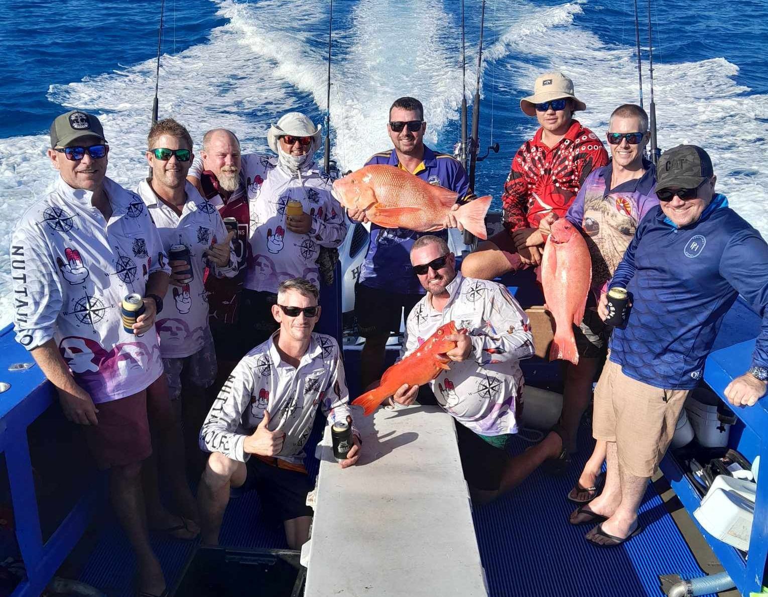 Group of Men On A Boat Fishing, Holding Up Large Red Fish, Smiles — Whitsunday Fishing Charters In Airlie Beach, QLD