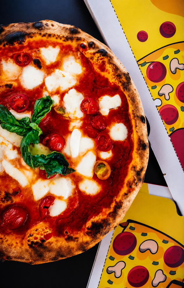 Il pizzaiolo Valentino Izzo che mostra una selezione di ingredienti di stagione