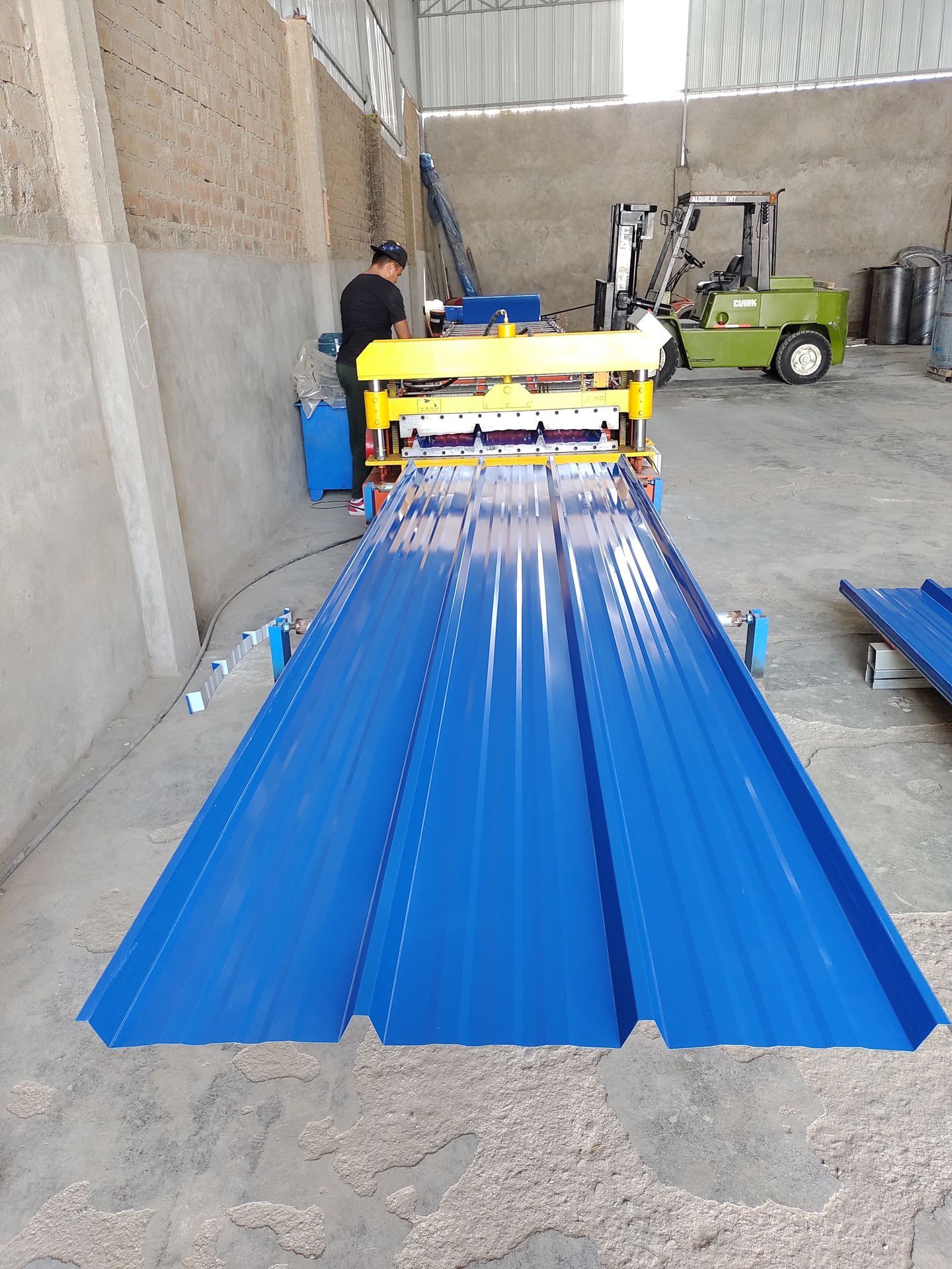 Un techo azul está siendo cortado por una máquina en un almacén.