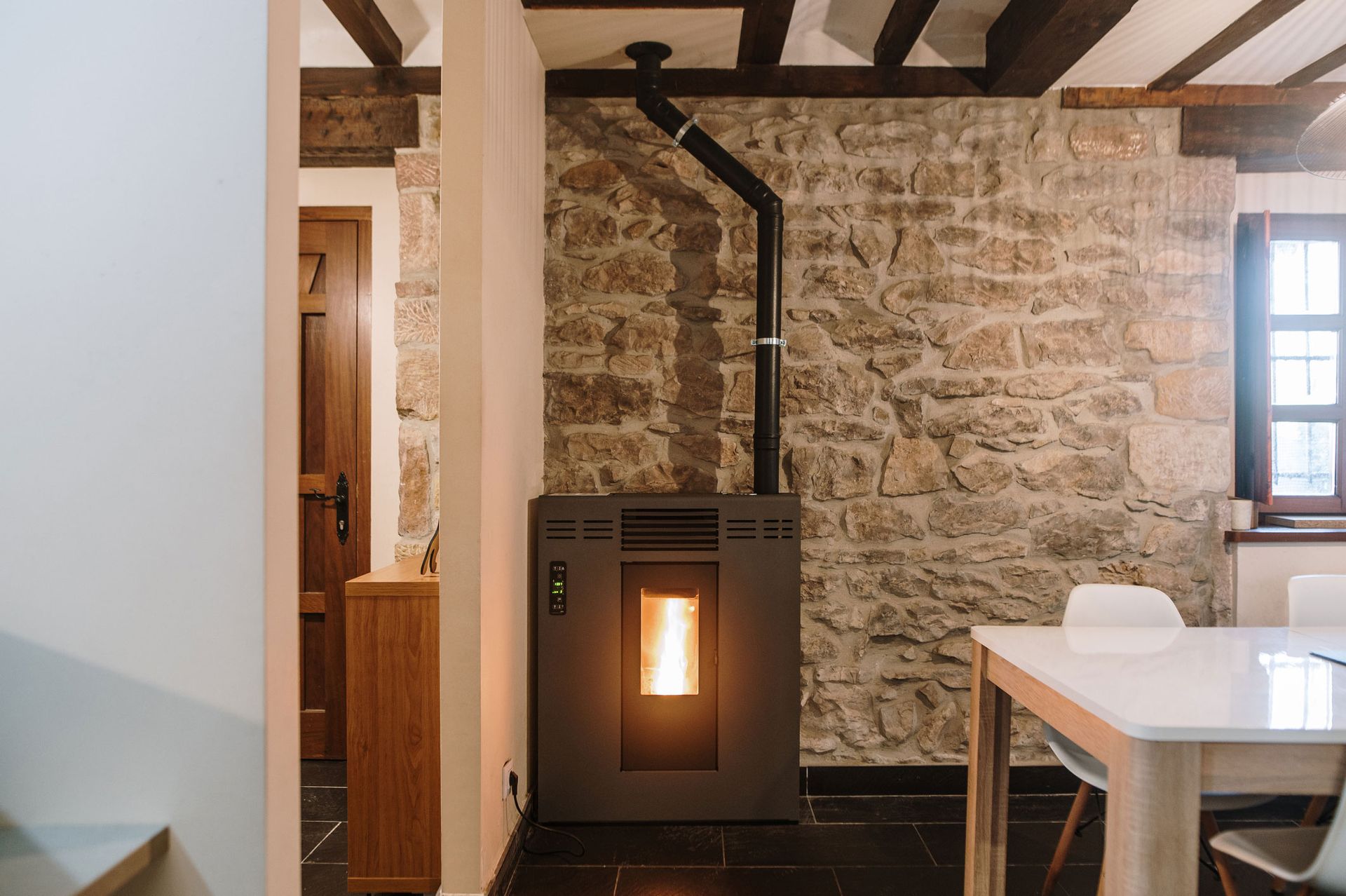 A room with a stove and a table in it
