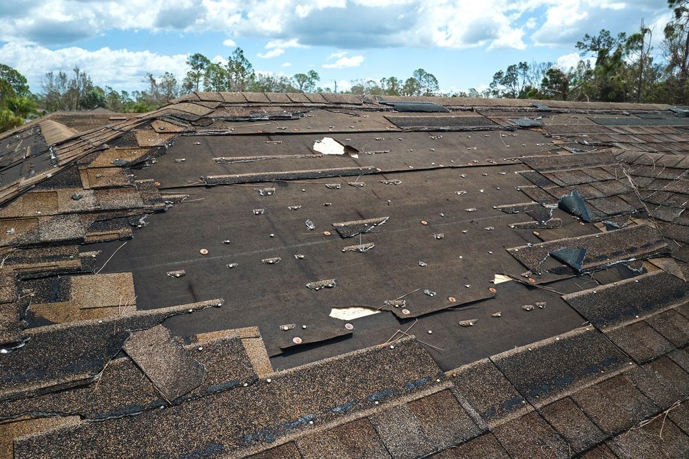 A roof with a lot of shingles missing and a hole in it