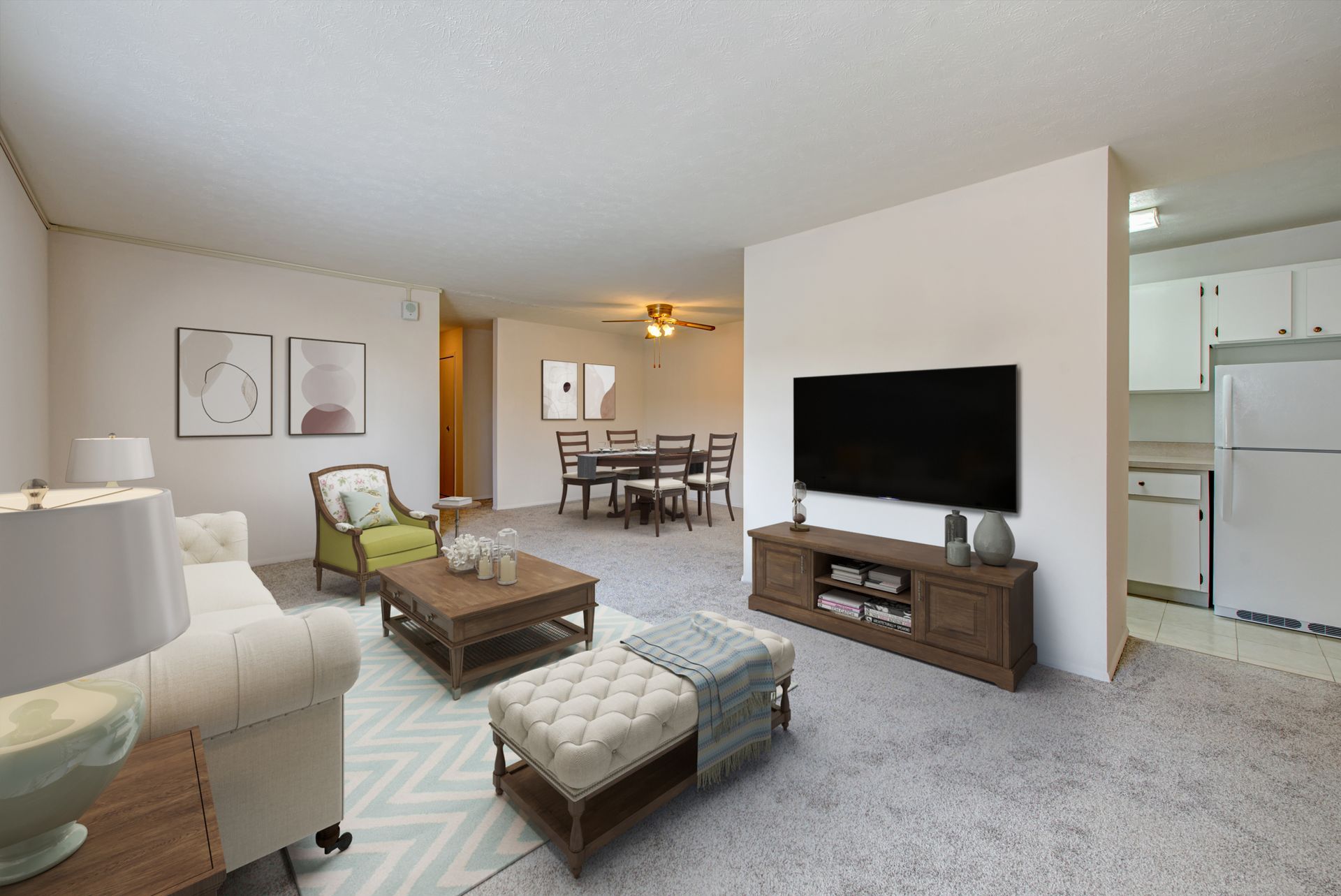 A living room with a couch , chairs , coffee table and television.