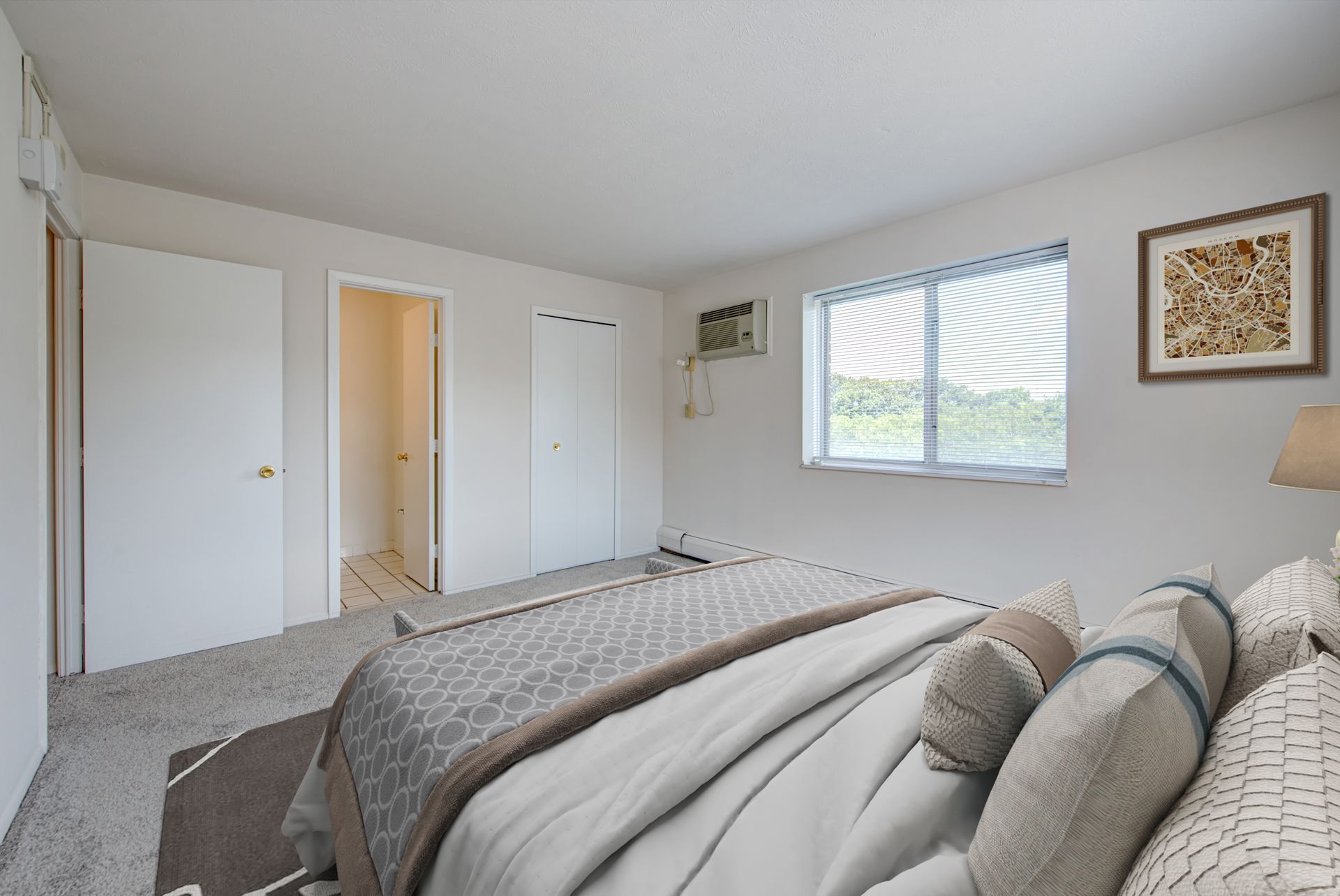 A bedroom with a large bed and a window.
