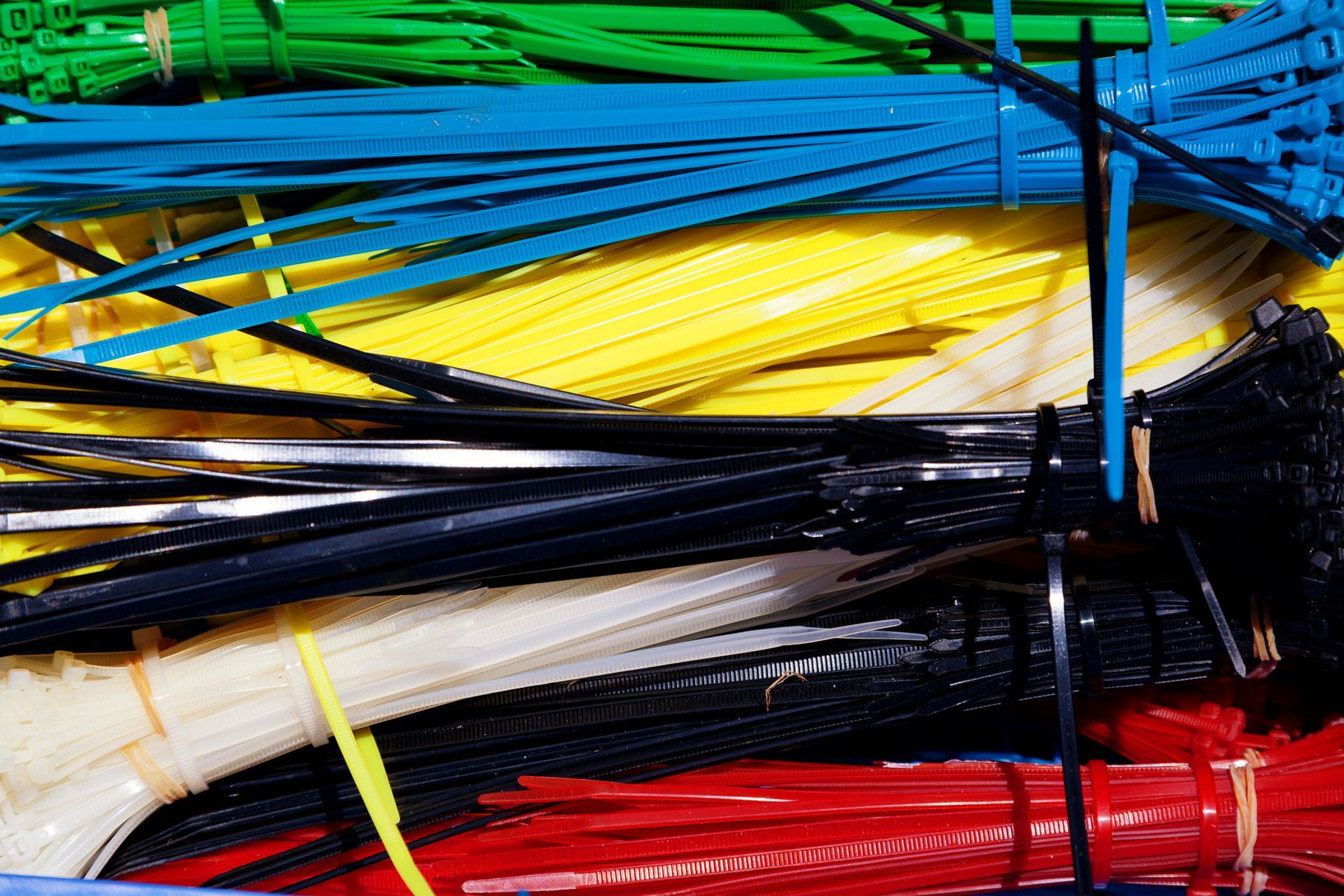 Close-up of a pile of colorful zip ties, including blue, yellow, black, white, and red.