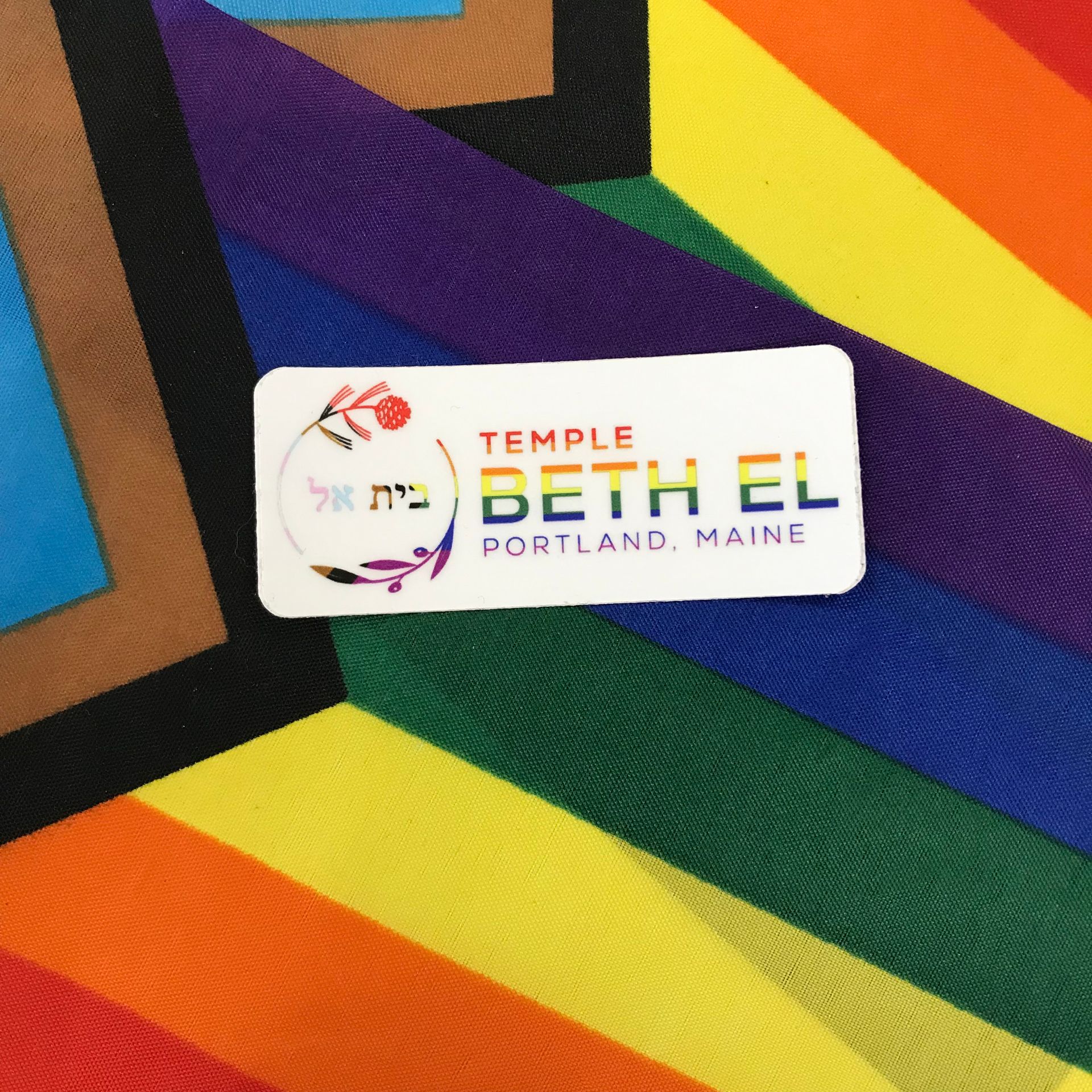 Four hands holding pride flags