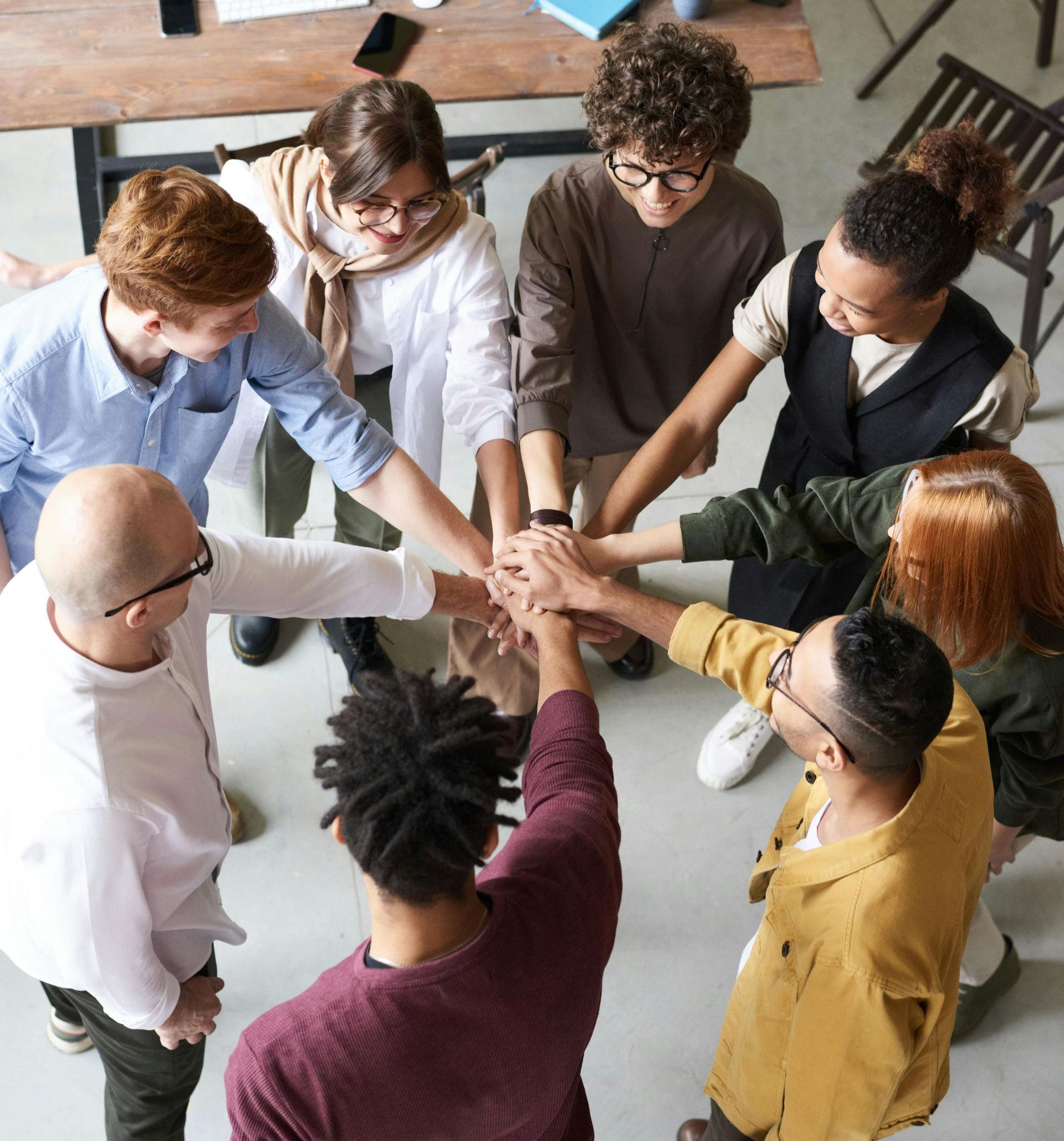 A group of people are putting their hands together in a circle.