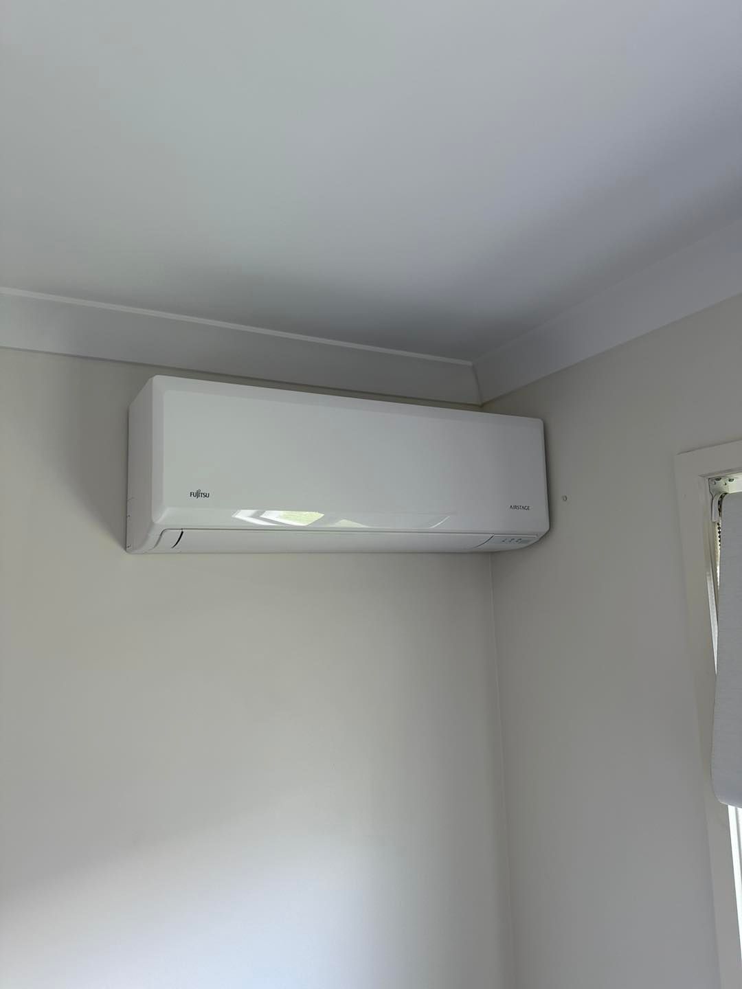 White Air Conditioning Unit Mounted on a Light-coloured Wall — DJL Refrigeration & Air Conditioning In Cannonvale, QLD