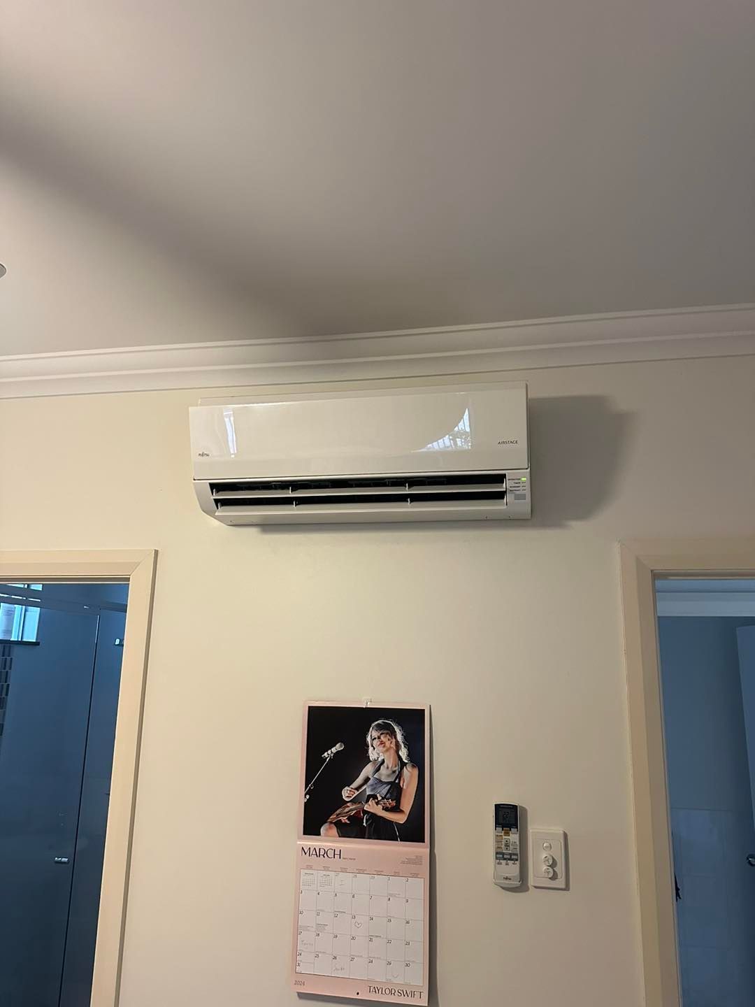 White Air Conditioner Mounted on a Beige Wall — DJL Refrigeration & Air Conditioning In Cannonvale, QLD