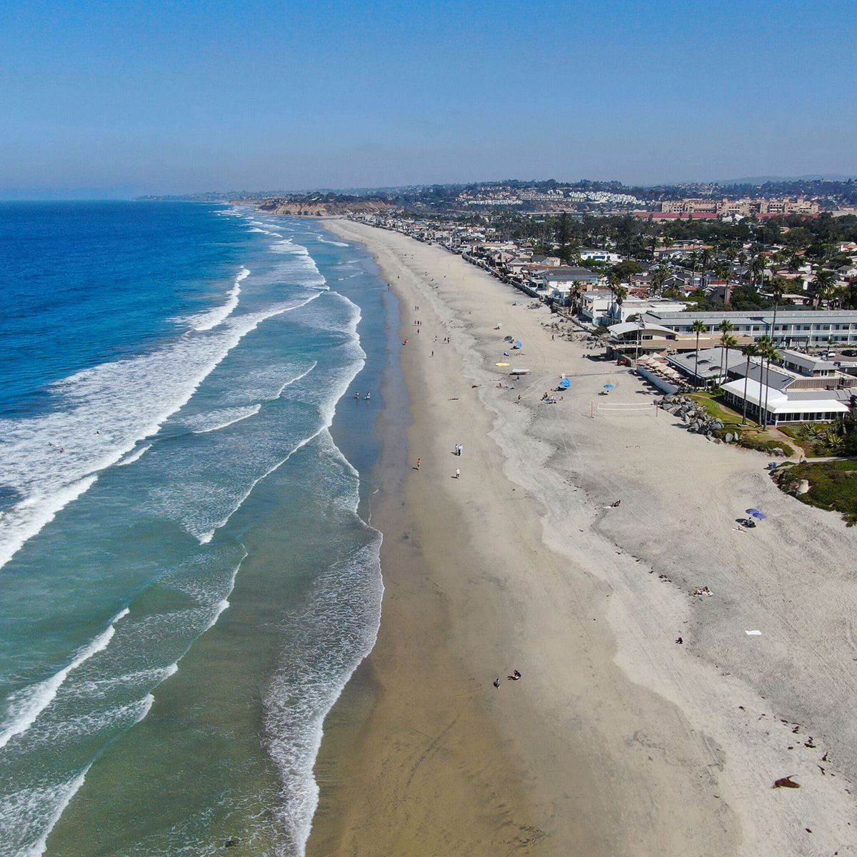 An aerial view of a beach with waves crashing on it