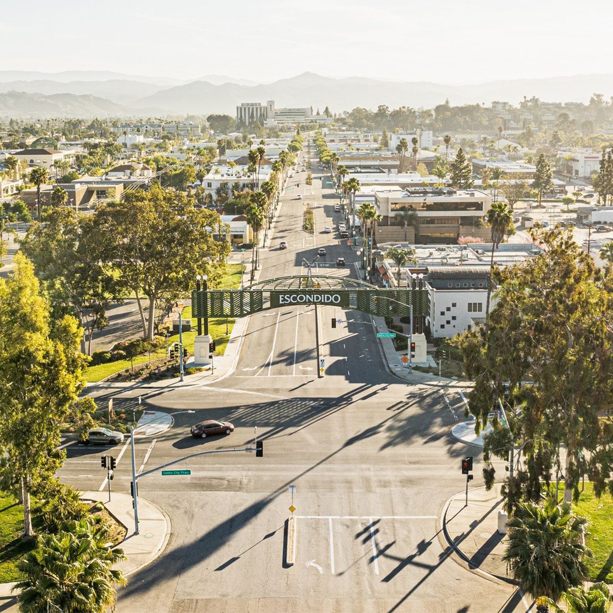 An aerial view of a city street with a bridge over it