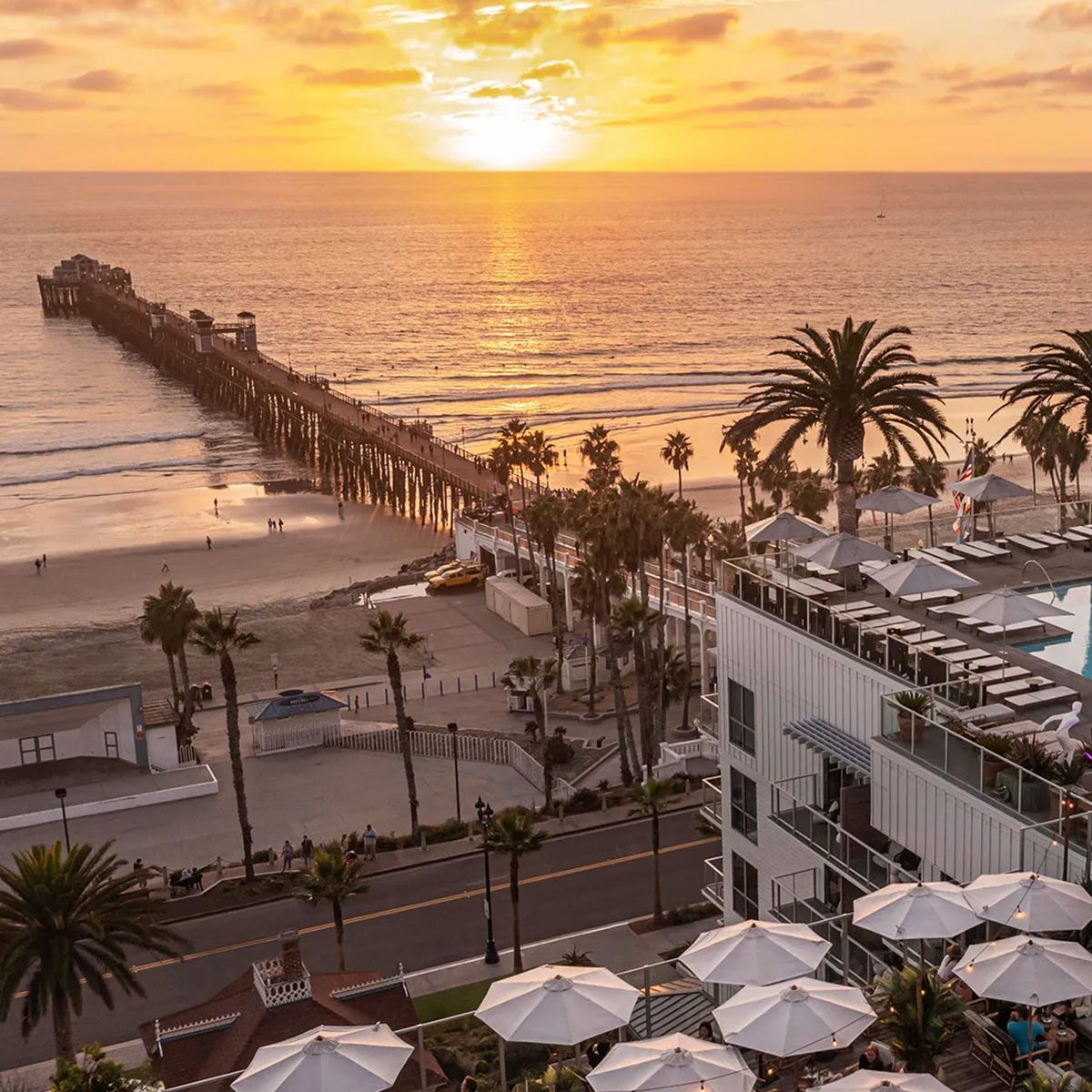 An aerial view of a pier and a beach at sunset