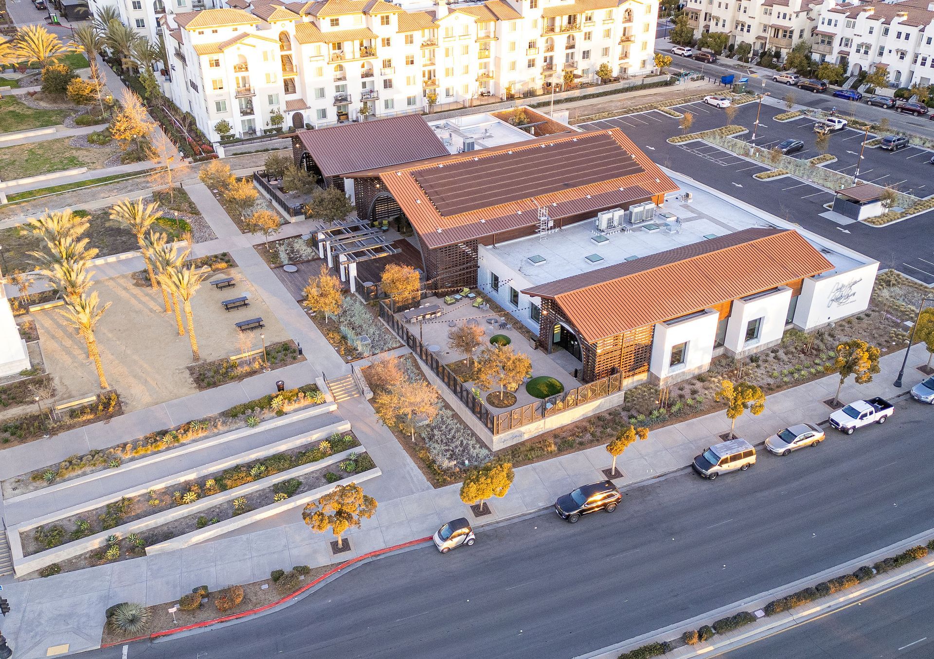 An aerial view of a building with a lot of cars parked in front of it.