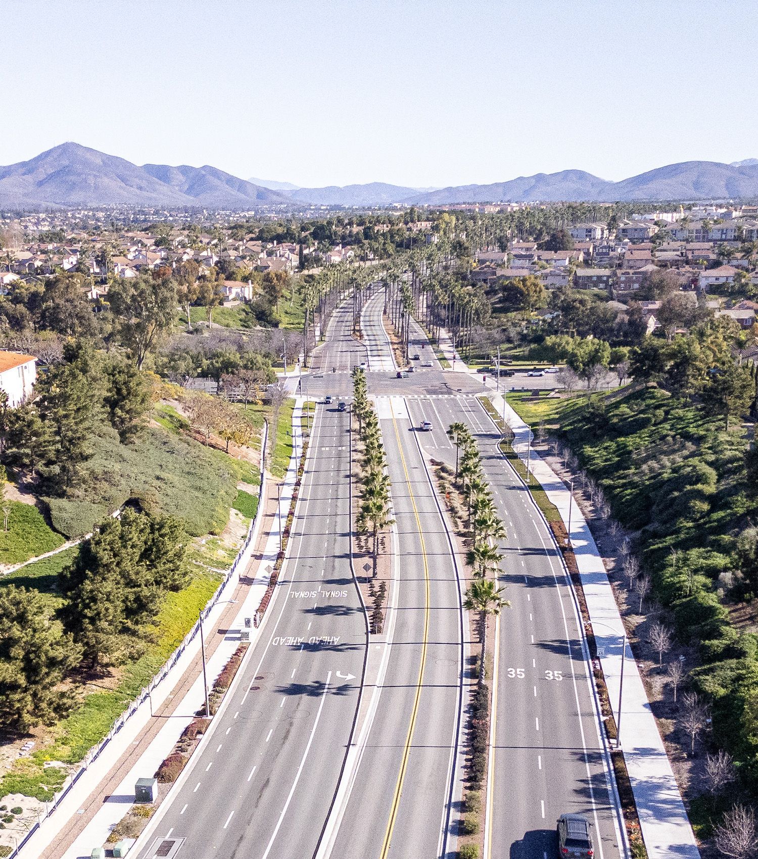 An aerial view of a highway with mountains in the background