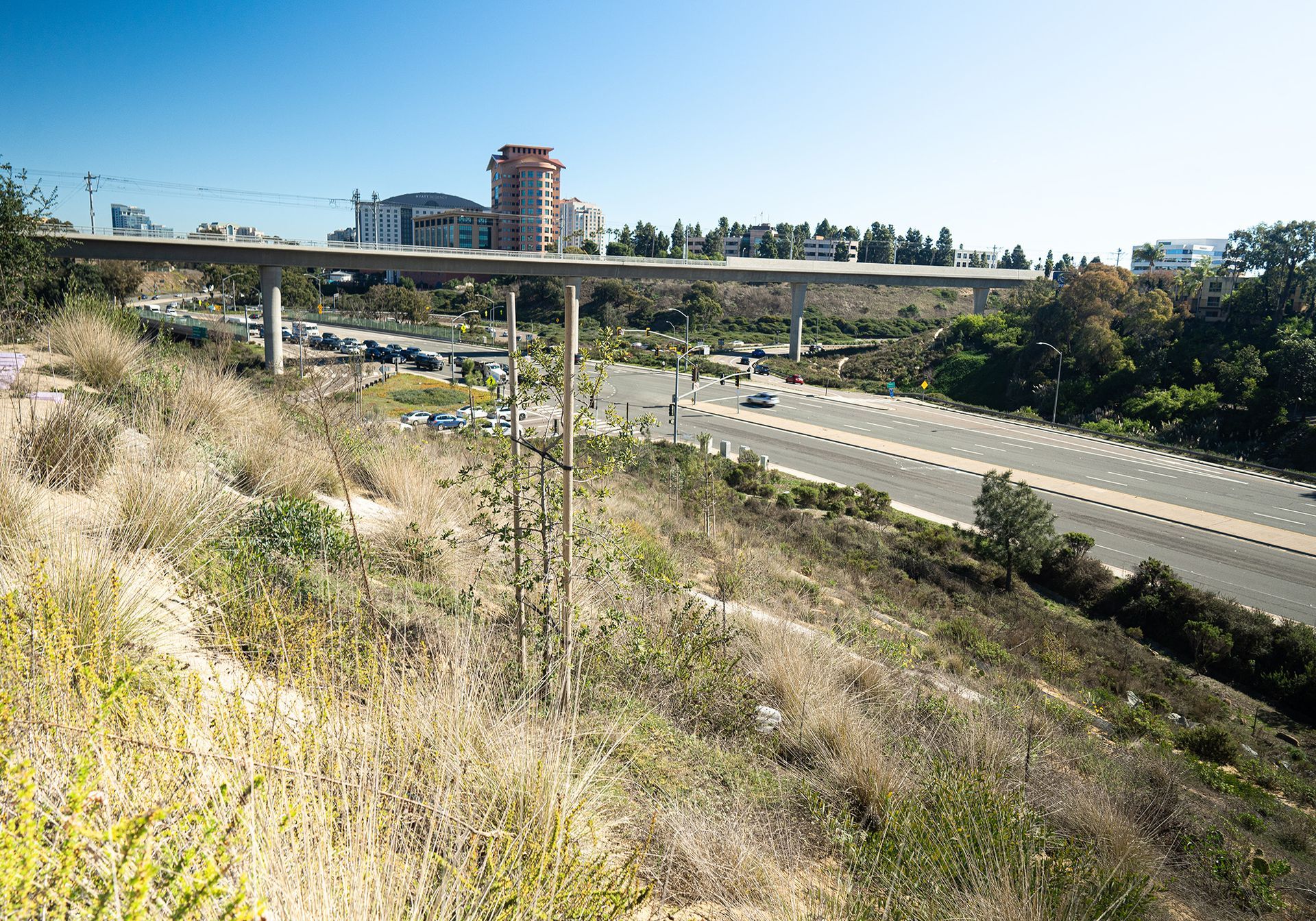 A bridge over a highway with a city in the background
