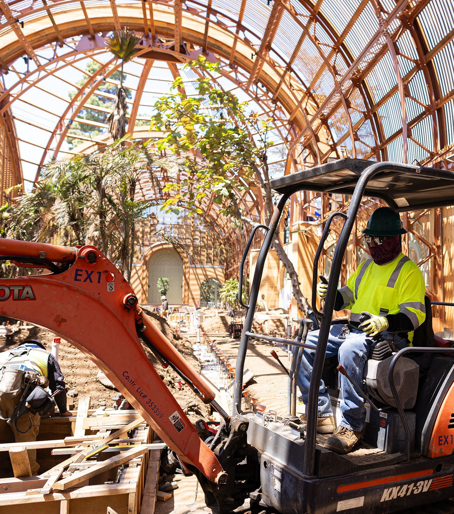 A man is driving an excavator in a building under construction.