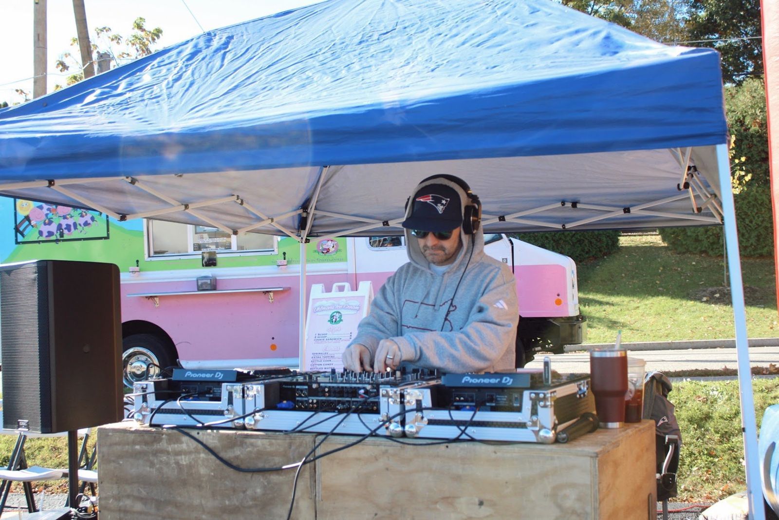 DJ Gerry at the DJ booth under a blue tent with an ice cream truck behind him