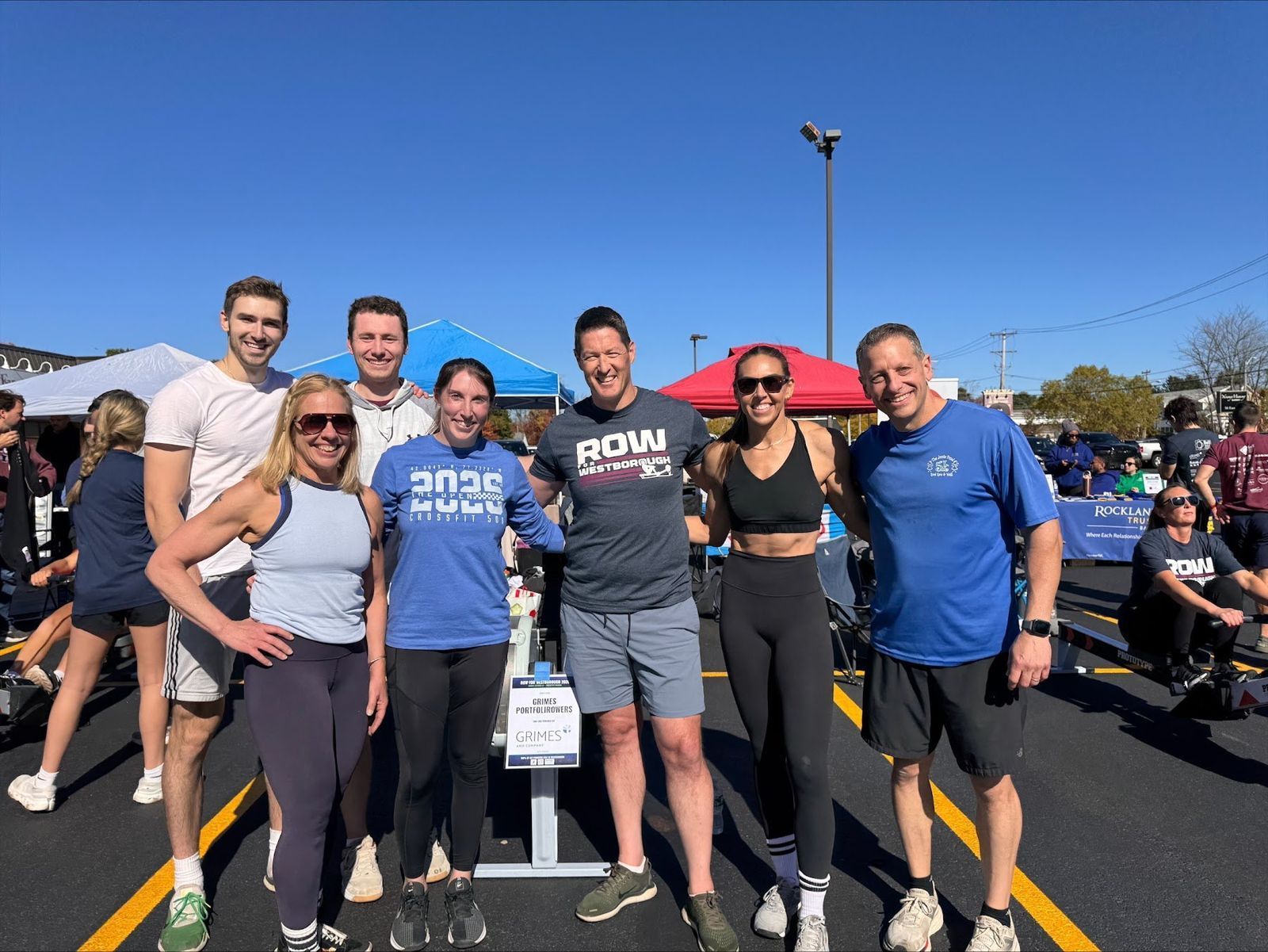 The Grimes PortfoliRowers crew posing together next to a rowing machine