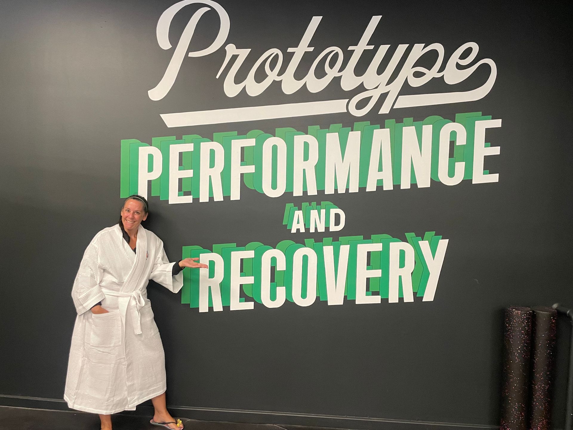 Person in white robe beside wall text reading “Prototype Performance and Recovery”