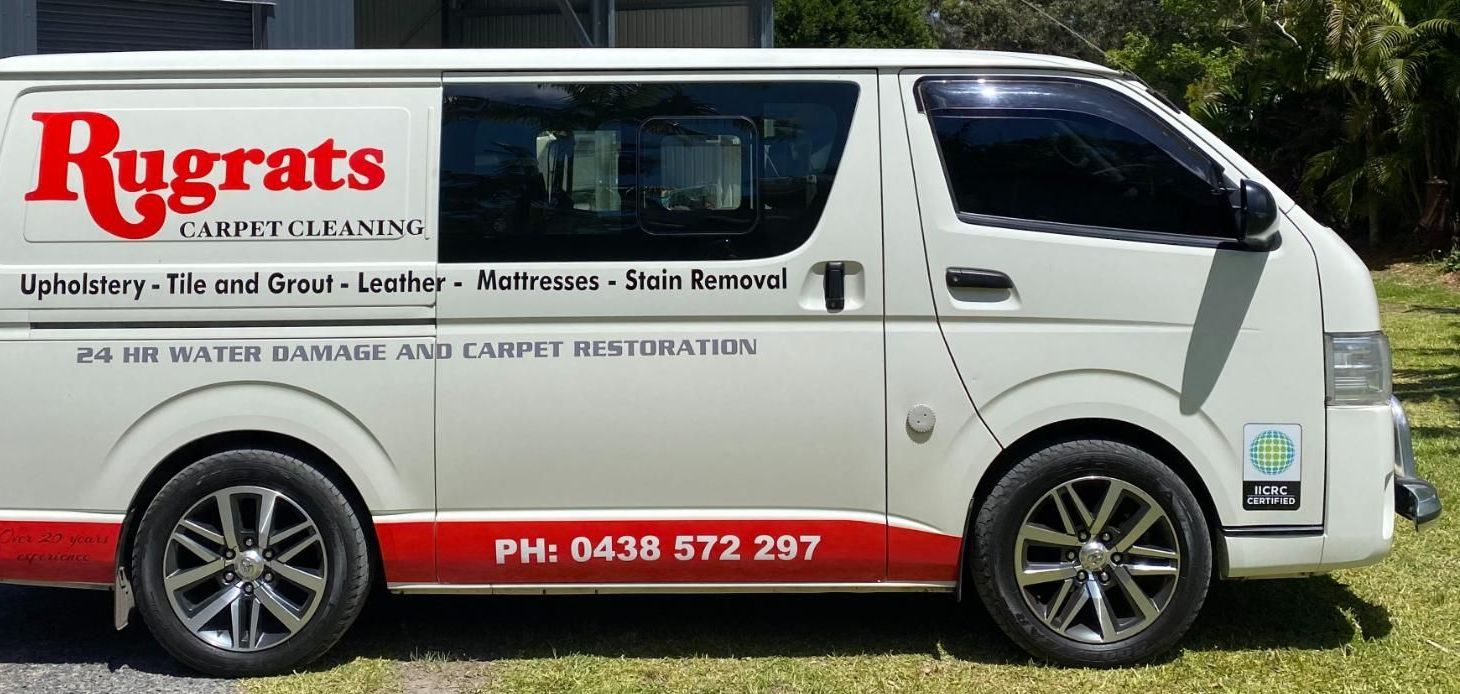White van with “Rugrats” logo and advertising text on the side, parked on grass — Rugrats Carpet Cleaning Service In Old Bar, NSW